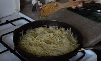 Переложите обжаренные овощи в другую емкость и заполните сковороду нарезанной капустой. Тушить 10-15 минут до мягкости.